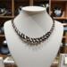 Handcrafted black and white Kumihimo necklace by Bead & Braid Collective displayed in boutique setting with spiral bead and braid accents